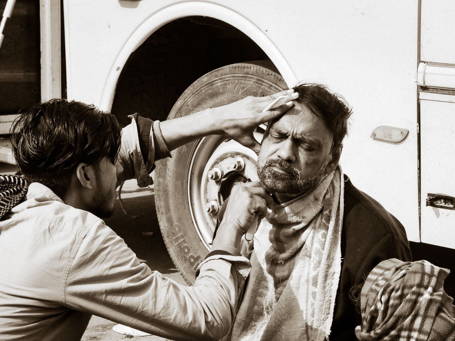 Man Being Shaved Outdoors In Black And White